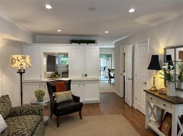 sitting room with dark wood finished floors, healthy amount of natural light, ornamental molding, and recessed lighting