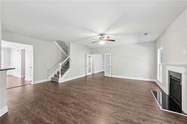unfurnished living room featuring visible vents, a ceiling fan, french doors, a fireplace, and stairs