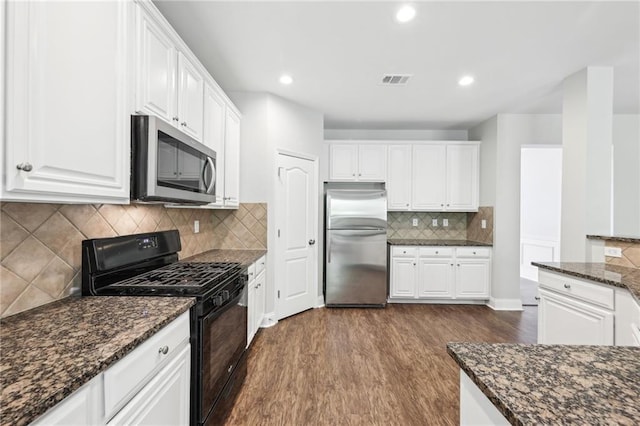 kitchen featuring white cabinets, dark wood-style flooring, appliances with stainless steel finishes, and visible vents