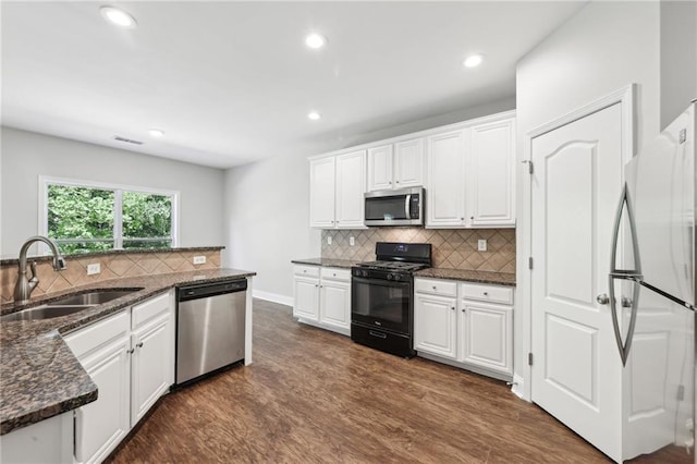 kitchen with dark wood-type flooring, white cabinets, appliances with stainless steel finishes, and a sink