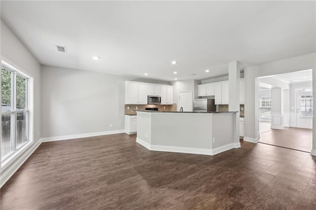 kitchen featuring dark countertops, appliances with stainless steel finishes, white cabinetry, dark wood-style flooring, and visible vents