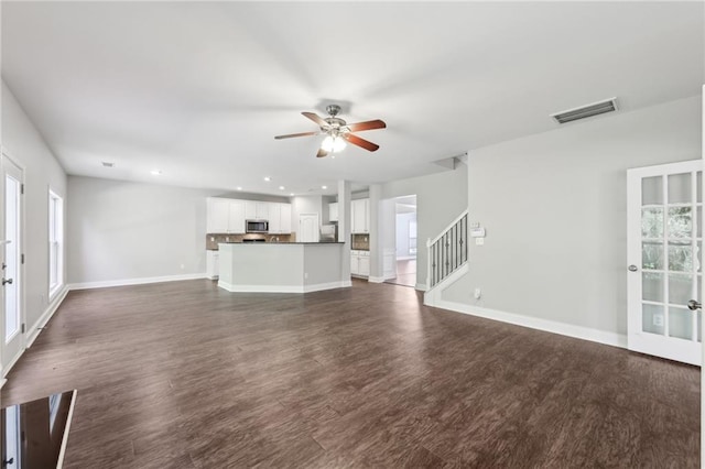 unfurnished living room featuring baseboards, visible vents, ceiling fan, and plenty of natural light