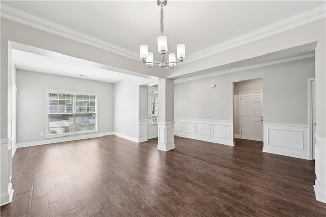 unfurnished dining area featuring a wainscoted wall, dark wood-style floors, a chandelier, and ornamental molding