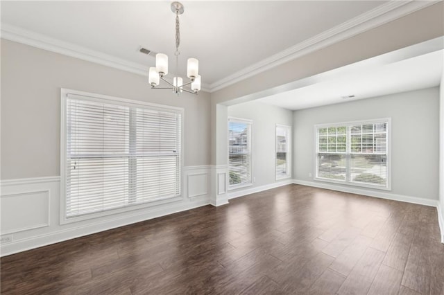 interior space featuring an inviting chandelier, ornamental molding, a wainscoted wall, and visible vents