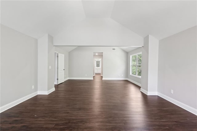 unfurnished living room with dark wood finished floors, vaulted ceiling, and baseboards