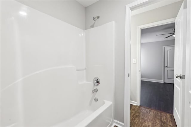 full bathroom with baseboards, wood finished floors, shower / bath combination, and ceiling fan