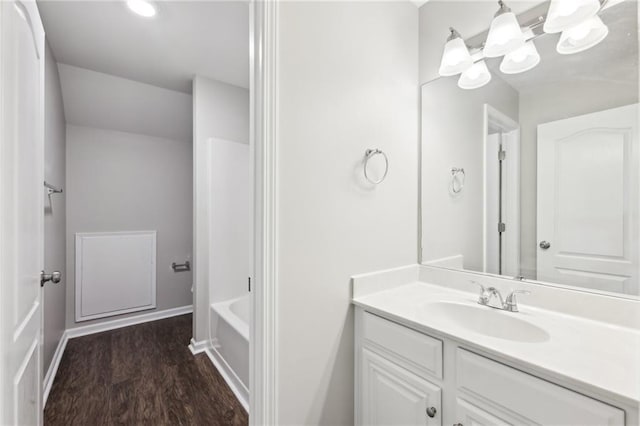 bathroom with baseboards, vanity, and wood finished floors