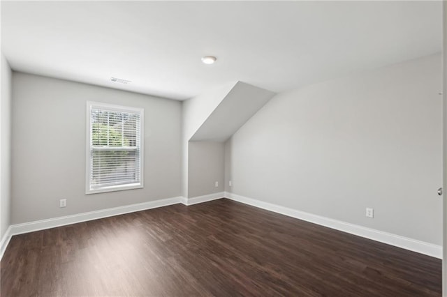 additional living space featuring baseboards, visible vents, and dark wood-style floors