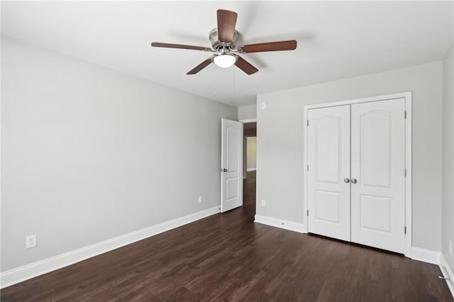 unfurnished bedroom featuring a closet, a ceiling fan, baseboards, and dark wood-style flooring
