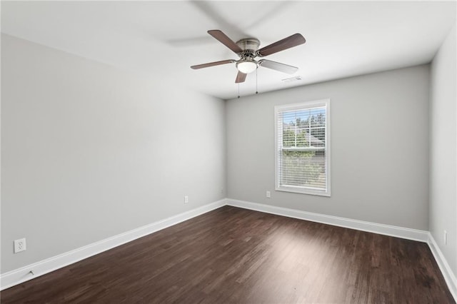 empty room featuring ceiling fan, baseboards, visible vents, and dark wood-style floors