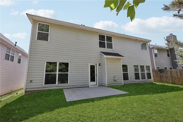 back of property with a lawn, a patio, and fence
