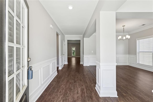 foyer entrance with wainscoting, a decorative wall, and dark wood-style floors