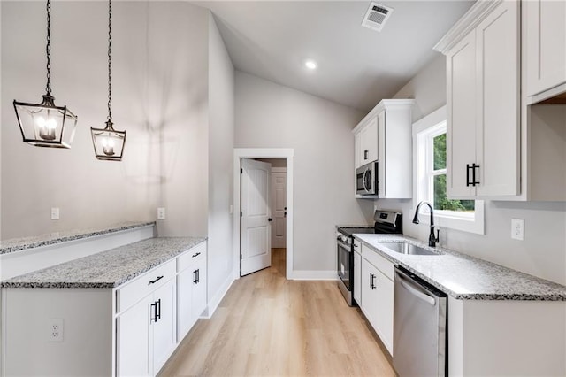 kitchen featuring appliances with stainless steel finishes, white cabinets, visible vents, and a sink