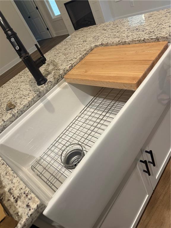 room details featuring wood finished floors and light stone countertops