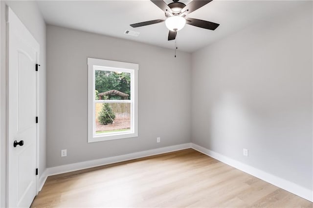 spare room with a ceiling fan, light wood-style flooring, and baseboards