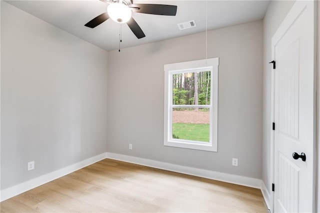 spare room featuring baseboards, attic access, visible vents, and wood finished floors