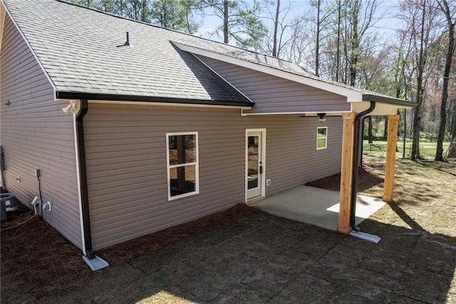 back of property featuring a shingled roof and a patio area