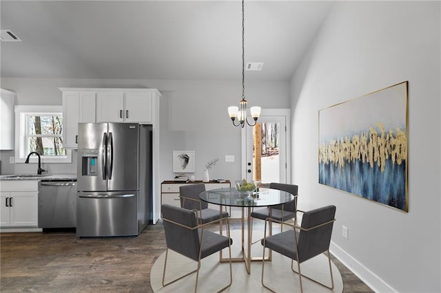 dining room with dark wood-style floors, a chandelier, visible vents, and baseboards