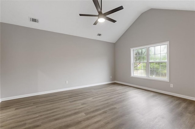 unfurnished room featuring a ceiling fan, visible vents, wood finished floors, and vaulted ceiling