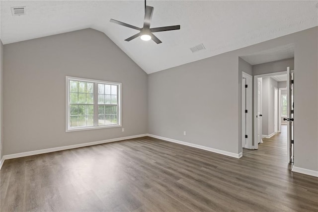 unfurnished room with ceiling fan, dark wood finished floors, baseboards, vaulted ceiling, and visible vents