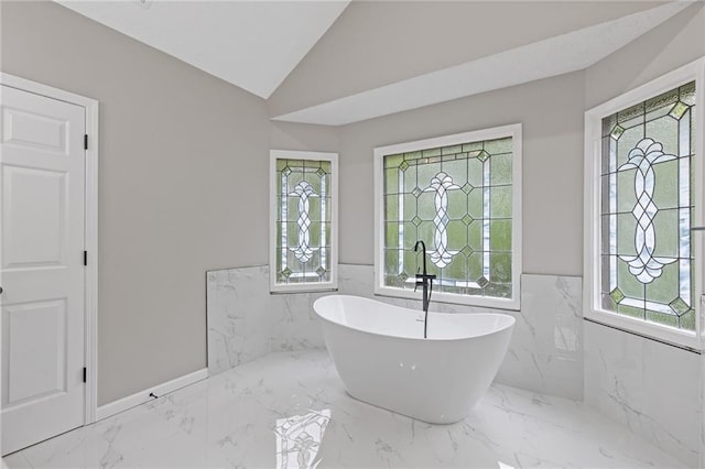 bathroom featuring wainscoting, a freestanding tub, and plenty of natural light