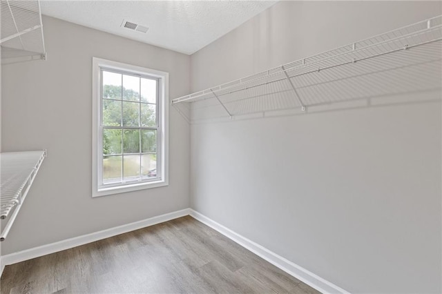 spacious closet featuring visible vents and wood finished floors