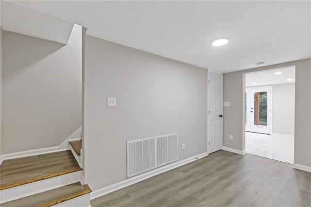 interior space featuring visible vents, wood finished floors, stairway, baseboards, and recessed lighting