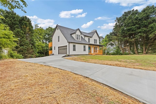 view of home's exterior with a garage, covered porch, a yard, and driveway