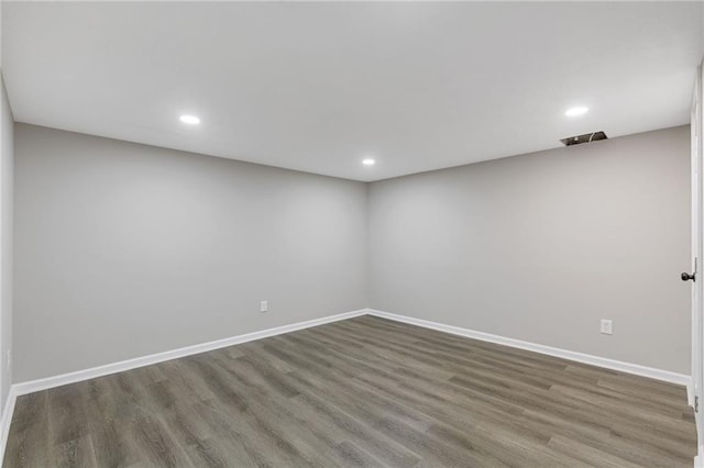 empty room with baseboards, recessed lighting, and wood finished floors