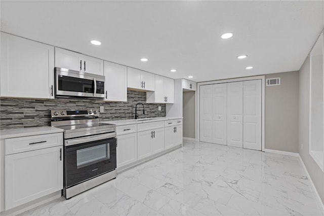 kitchen with visible vents, a sink, baseboards, and appliances with stainless steel finishes