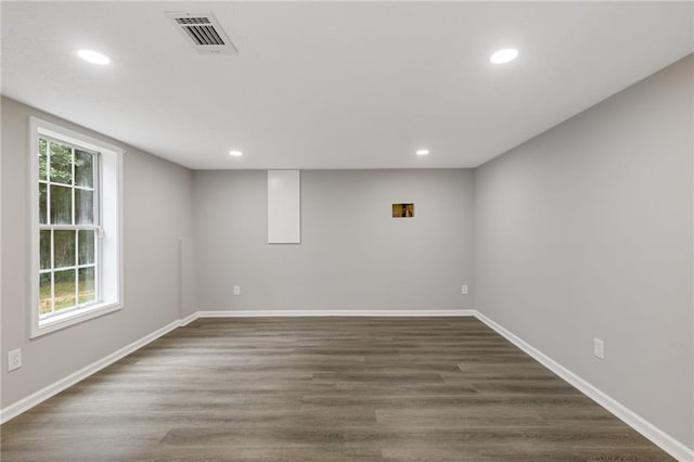 below grade area featuring visible vents, recessed lighting, dark wood finished floors, and baseboards