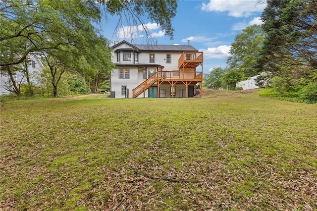 rear view of property with a wooden deck, a yard, and stairway