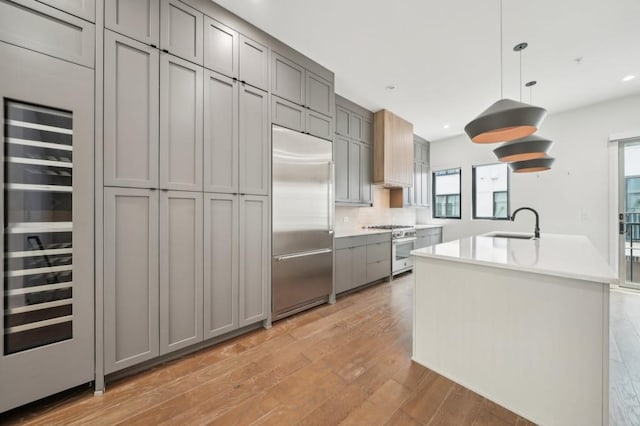 71 Krog St NE, Atlanta, GA 30307 - kitchen featuring high quality appliances, gray cabinets, a sink, light wood finished floors, and wine cooler