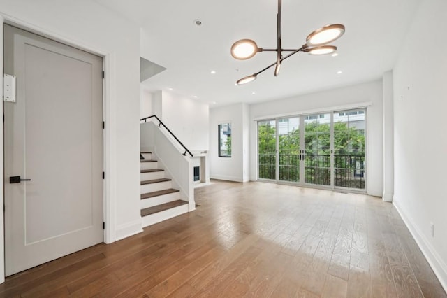 71 Krog St NE, Atlanta, GA 30307 - unfurnished living room with hardwood / wood-style floors, stairway, a chandelier, and baseboards