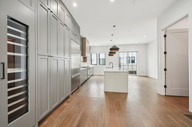 71 Krog St NE, Atlanta, GA 30307 - kitchen featuring gray cabinetry, a sink, light wood-type flooring, an island with sink, and recessed lighting