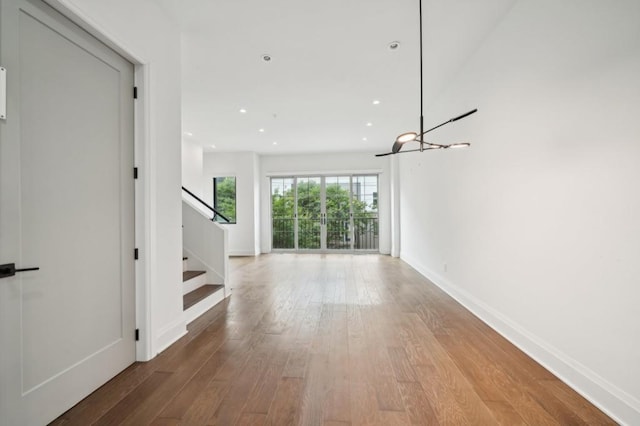 71 Krog St NE, Atlanta, GA 30307 - unfurnished living room with wood finished floors, stairs, baseboards, recessed lighting, and a chandelier