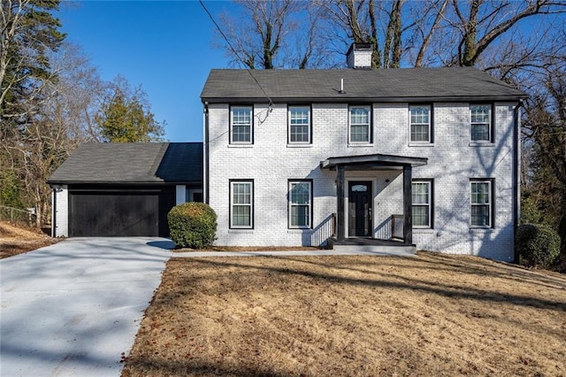 colonial home featuring a garage and a front lawn