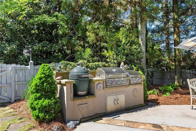 view of patio / terrace featuring grilling area, an outdoor kitchen, and fence
