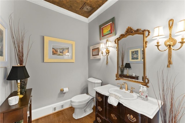 bathroom featuring ornamental molding, visible vents, toilet, wood finished floors, and baseboards