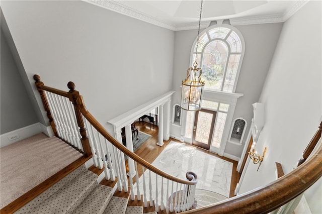 foyer featuring ornamental molding, stairway, a high ceiling, and wood finished floors