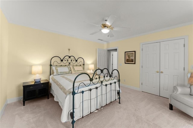 carpeted bedroom with baseboards, a closet, crown molding, and a ceiling fan
