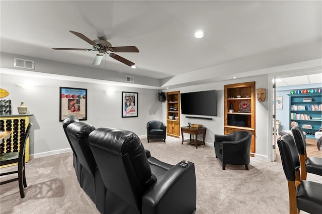 home theater featuring baseboards, recessed lighting, a ceiling fan, visible vents, and light colored carpet