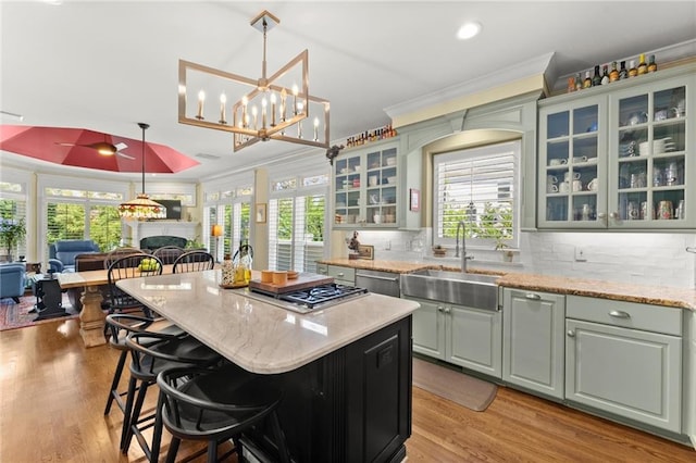 kitchen with plenty of natural light, a center island, a sink, and ornamental molding