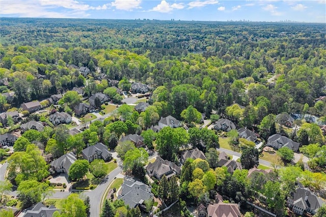 drone / aerial view featuring a residential view and a view of trees