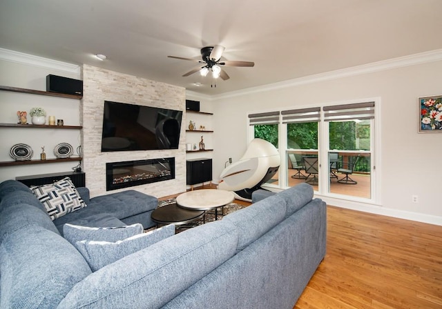 2521 Wood Creek Ct, Dacula, GA 30019 - living room with ornamental molding, light wood-style flooring, a ceiling fan, and a large fireplace