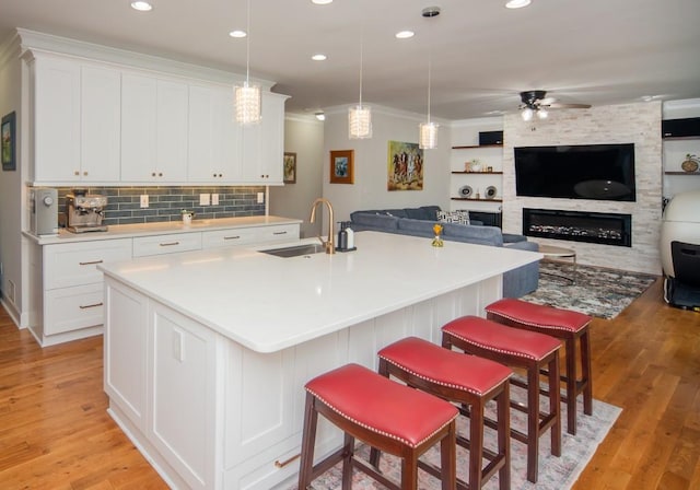2521 Wood Creek Ct, Dacula, GA 30019 - kitchen featuring ceiling fan, open floor plan, white cabinetry, ornamental molding, and light countertops