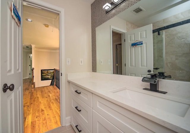 2521 Wood Creek Ct, Dacula, GA 30019 - bathroom featuring vanity, wood finished floors, tiled shower, and ornamental molding