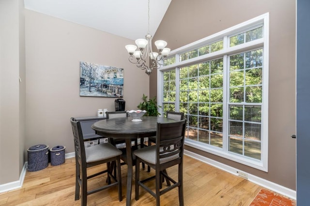 dining space with vaulted ceiling, a chandelier, and hardwood / wood-style floors