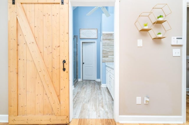 hall with hardwood / wood-style floors and a barn door