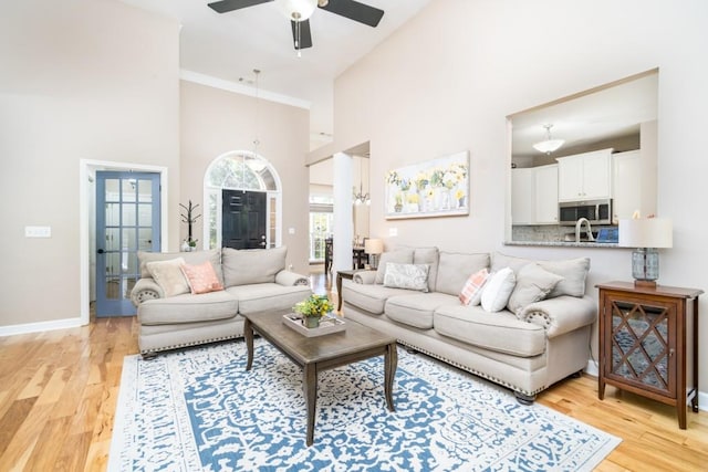 living room featuring ceiling fan, light hardwood / wood-style floors, and high vaulted ceiling